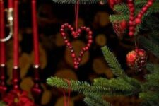 simple and cool heart-shaped cranberry Christmas ornaments paired with usual red baubles are amazing to style a Christmas tree