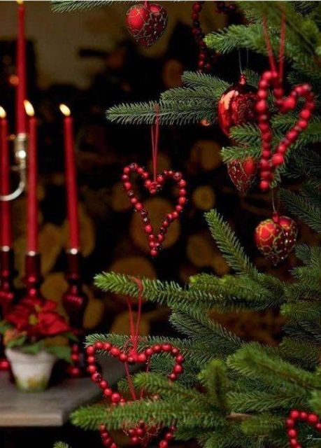 simple and cool heart-shaped cranberry Christmas ornaments paired with usual red baubles are amazing to style a Christmas tree