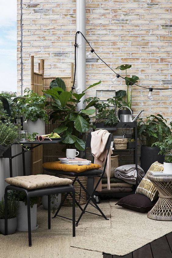 a Nordic balcony with jute rugs, black metal furniture, potted plants and lights, a wooden side table feels like an orangery