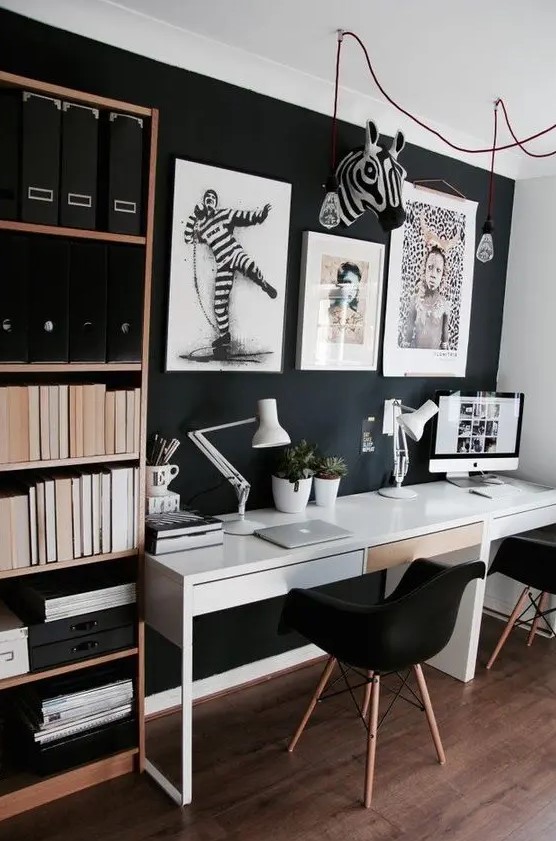 a Scandinavian home office with a black wall, a shelving unit and a shared white desk, bold artworks for cool wall decor