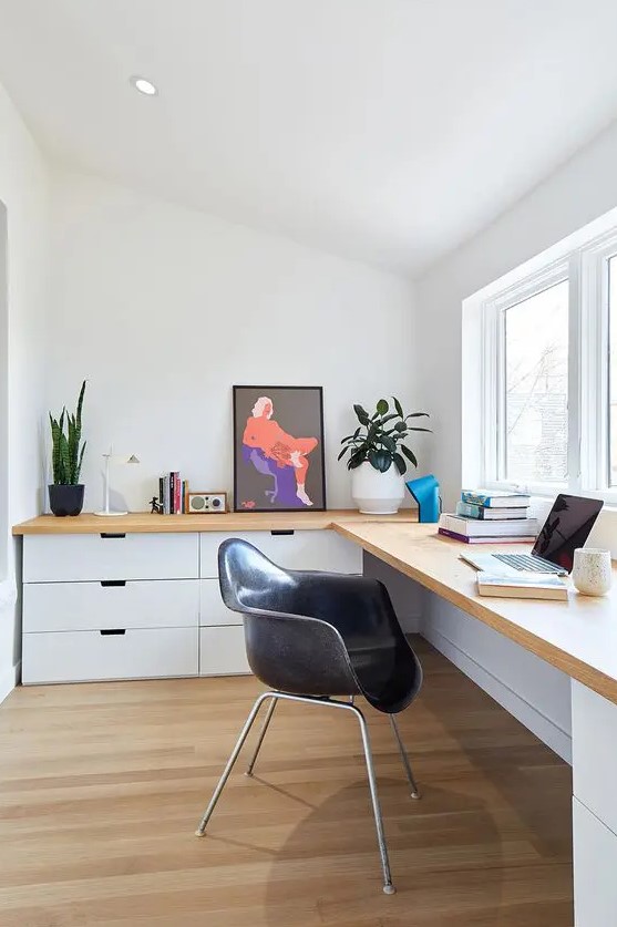 a Scandinavian home office with a large corner desk with lots of drawers,a small window and potted greenery is cool for working