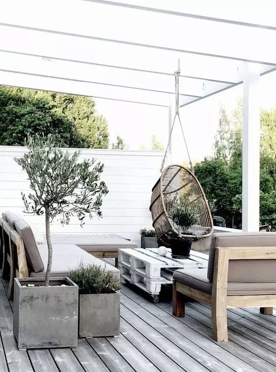 a Scandinavian terrace with concrete planters, wooden and pallet furniture and a hanging rattan chair a Scandinavian terrace with concrete planters, wooden and pallet furniture and a hanging rattan chair