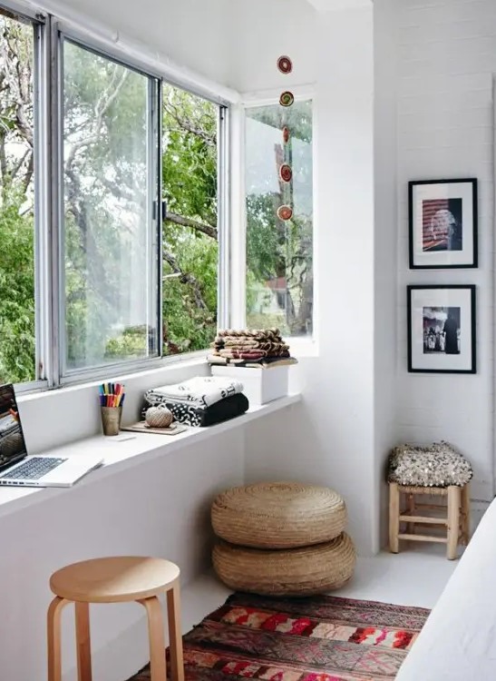 a beautiful Scandinavian space with a windowsill desk, jute poufs, a bold printed rug and lovely furniture