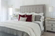 a beautiful and airy bedroom with a grey upholstered bed, neutral bedding, a grey upholstered bench and burgundy and grey pillows