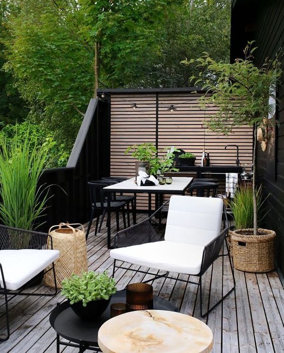 a cool summer terrace in Scandi style a chic and lively Scandinavian summer terrace with black and white furniture, a small kitchen countertop with a sink, a dining and sitting space