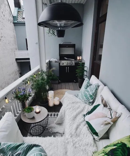 a cozy Nordic balcony with potted plants, printed textiles and a grill - all you need in one