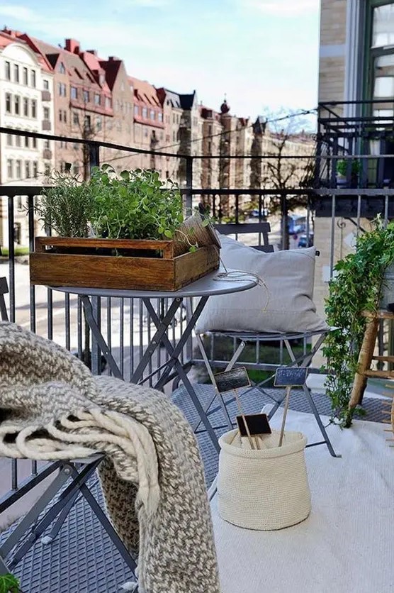 a cozy Scandi balcony, a rug, pillows, throws, potted plants and tiny coffee tables for winter