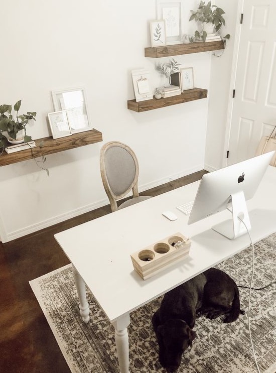a cozy and simple home office with floating shelves, a simple white desk and a refined chair plus a printed rug