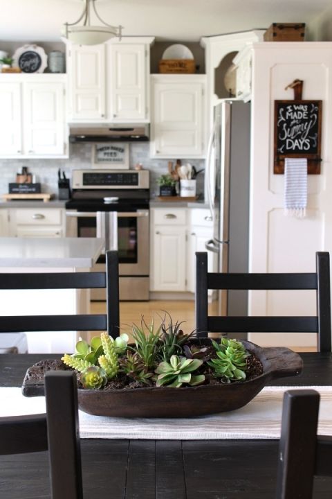 a dark dough bowl with succulents and air plants may act as a planter or a vase for arrangements