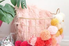 a gold wire basket with colorful ombre pompoms covering it is a very fun and cool idea for decor
