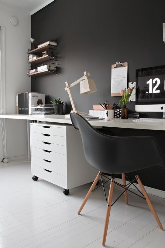 a moody Scandi home office with a black statement wall, chair and soem decor and white as the base