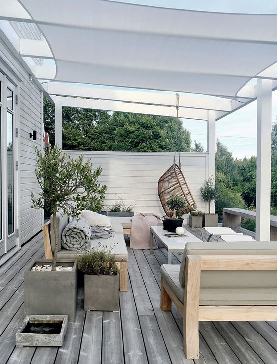 a neutral Scandinavian terrace with olive green upholstered furniture, folding chairs and a coffee table, a pendant chair and potted plants a neutral Scandinavian terrace with olive green upholstered furniture, folding chairs and a coffee table, a pendant chair and potted plants