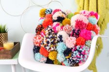 a pillow fully made of colorful pompoms is a very bright and cool decoration to accent your interior
