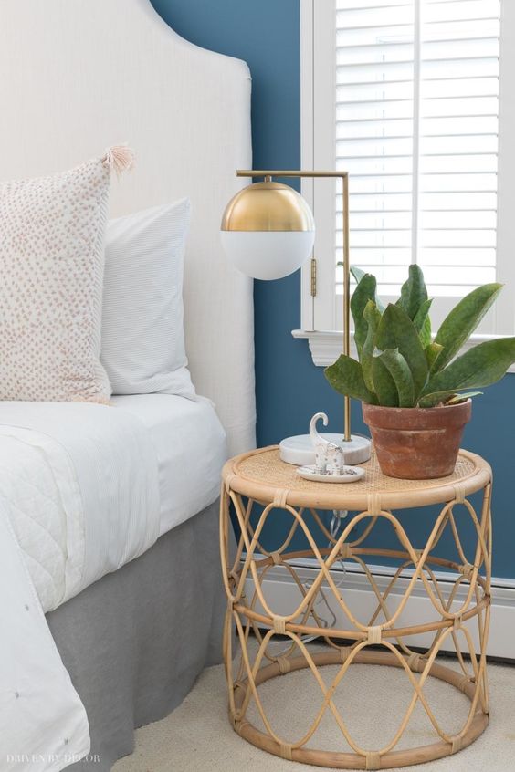 a rattan and cane small roung nightstand, a gold table lamp and a potted plant will compose a beautiful and cool combo for a bedroom