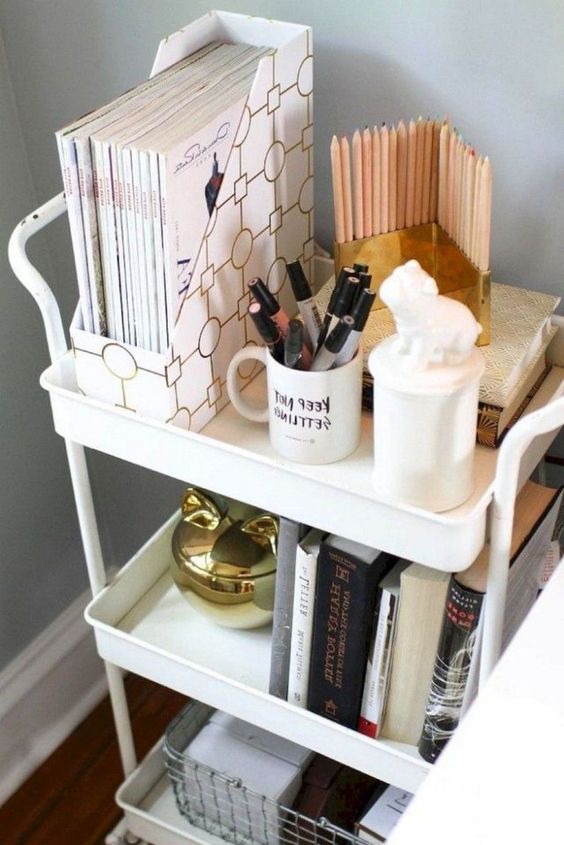 a small white tiered cart on casters, with some books, touches of gold and other stuff is a lovely solution for a nightstand