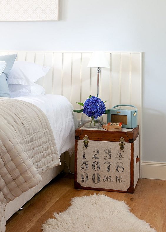 a small wooden chest with vintage numbers and some more vintage pieces on top is a lovely idea of a nightstand, with a story