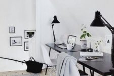 a welcoming Scandinavian space with a black desk and white chairs, black lamps and printed rugs
