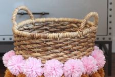 a woven basket decorated with colorful pompoms is a nice storage unit that you may use