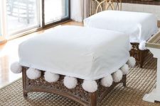 rattan ottomans with white covers and large white pompoms are amazing to give a chic feel to the space
