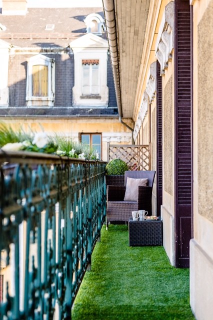 An artificial grass rug and several window box planters with little flowers in them would make your balcony a small urban garden.