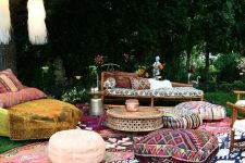a boho lounge with printed rugs, ottomans and upholstery and tassels hanging