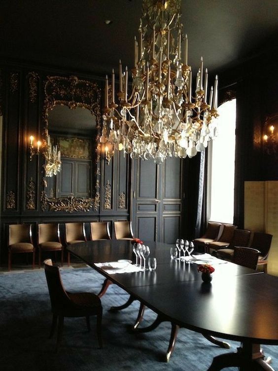 https://www.digsdigs.com/photos/2014/02/a-jaw-dropping-Gothic-dining-room-with-black-and-gold-paneled-walls-a-large-mirror-an-oval-table-upholstered-chairs-and-a-fantastic-chandelier.jpg