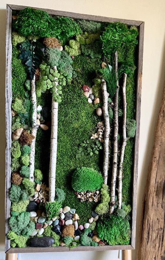 a large moss wall art with branches and pebbles is a stylish idea for a modern space, it feels very outdoorsy