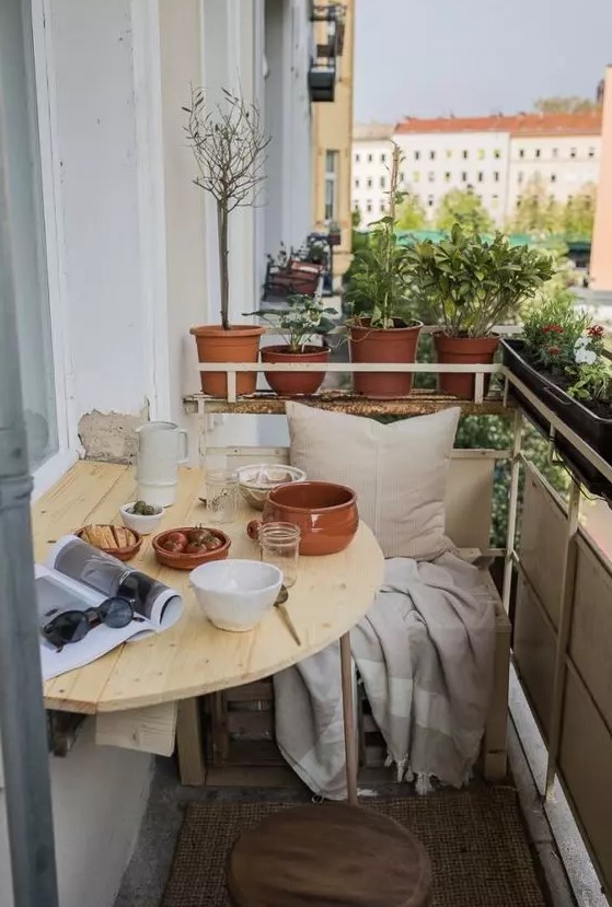 a light-stained wooden folding table is a lovely idea for a tiny balcony, you may use it as a planter stand or to serve something