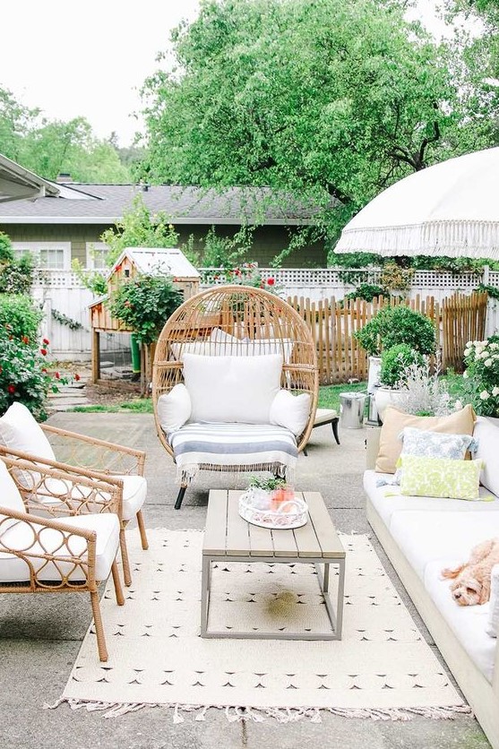 a lively summer terrace with rattan furniture, a comfy sofa, printed textiles, a low table and lots of greenery around a lively summer terrace with rattan furniture, a comfy sofa, printed textiles, a low table and lots of greenery around