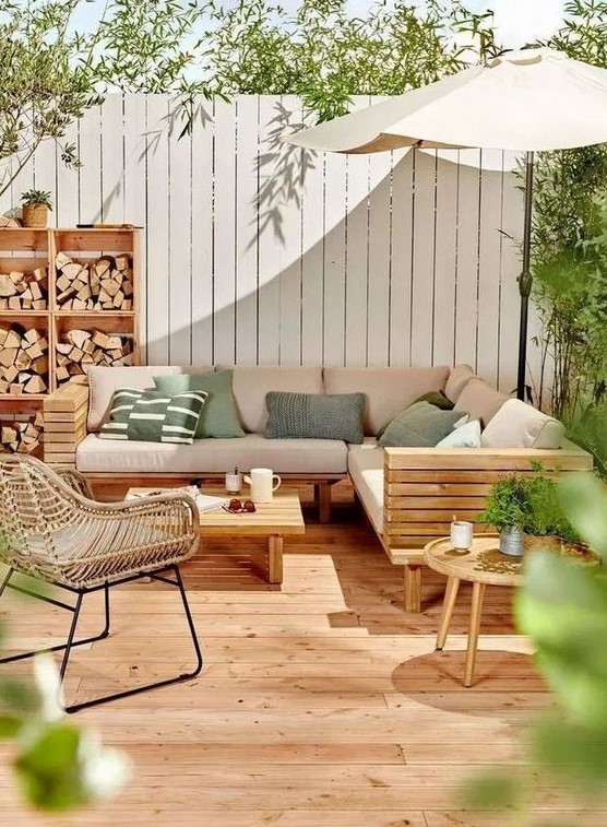 a lovely modern terrace with a wooden deck, a planked sofa and a table, a rattan chair, a storage unit with firewood a lovely modern terrace with a wooden deck, a planked sofa and a table, a rattan chair, a storage unit with firewood