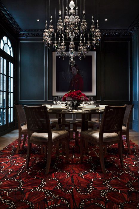 https://www.digsdigs.com/photos/2014/02/a-modern-Gothic-dining-room-with-black-paneled-walls-a-glass-table-and-upholstered-chairs-a-red-carpet-and-a-crystal-chandelier.jpg