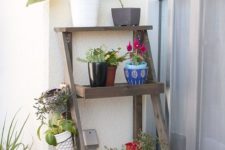 a simple foldable piece of furniture features three shelves for all the stuff you need