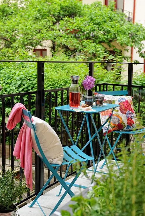 blue metal furniture, colorful printed textiles, lots of greenery here and there for a bold and bright space
