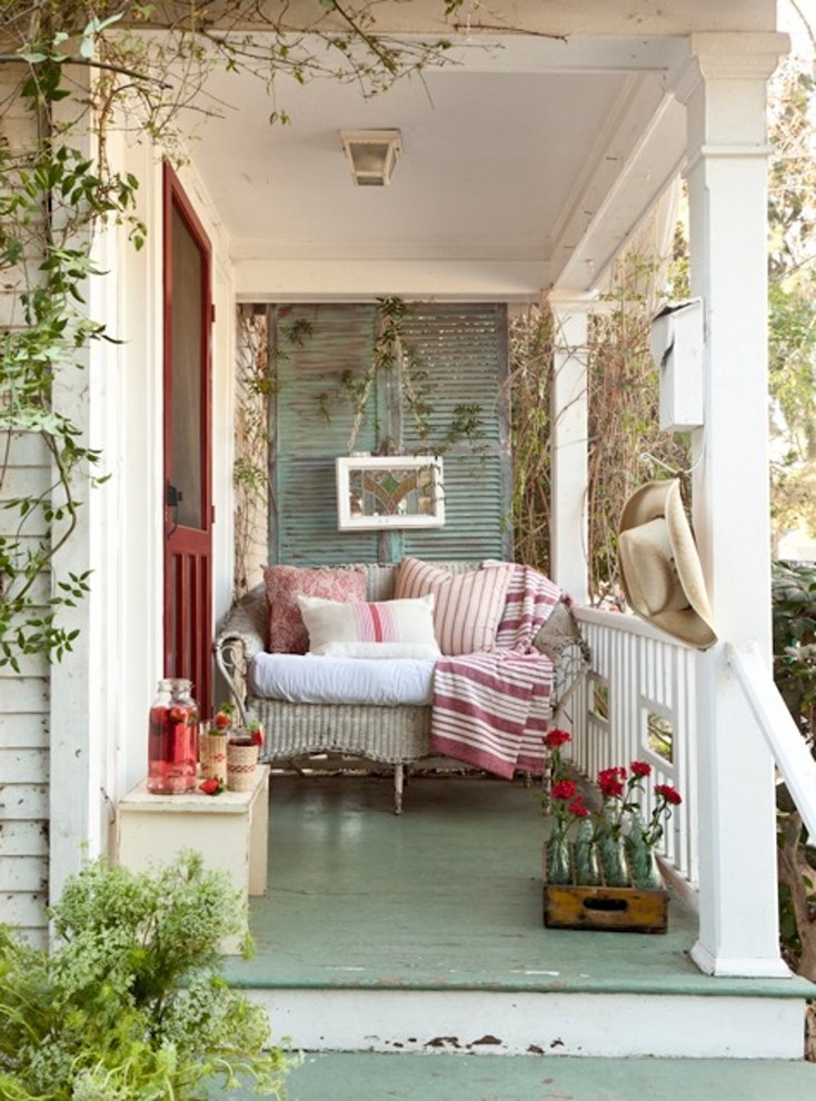 vintage inspired compact front porch with a seeting area and wine-colored front door