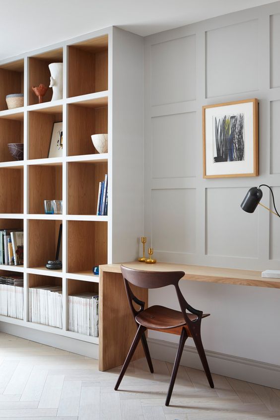 a beautiful minimalist home office with built-in bookshelves and a small built-in desk is a stylish space