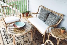 a boho porch with rattan furniture, neutral and printed textiles and potted greenery is a chic idea