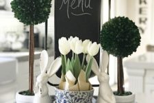 a bucket tray with greenery topiaries, white tulips and bunnies for a farmhouse spring feel in the kitchen