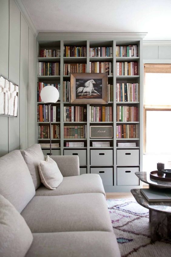 a built-in bookshelf unit with box drawers and a large artwork on it is perfect for a contemporary space