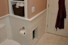 a built-in cat toilet unit in the powder room, with an entrance and clad with tiles to perfectly match the house