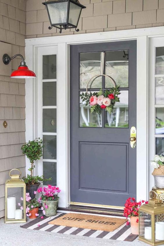 a chic spring porch done with bright potted blooms, candle lanterns and a modern hoop floral wreath on the door