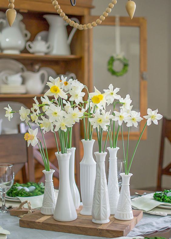 a cluster centerpiece of milk glass vases with daffodils is a pretty idea for a spring rustic feel, make one yourself