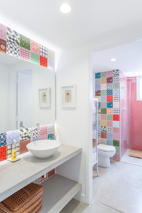a contemporary bathroom accented with red tiles in the shower space and with super bold printed tiles in the sink and toilet space