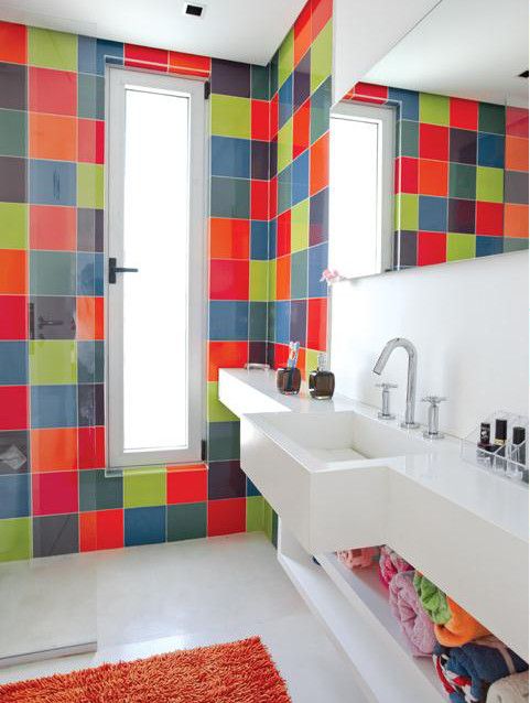 a contemporary bathroom clad with super bright tiles but  with a white built-in vanity and shelf plus a bold rug is amazing