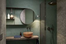 a creative small bathroom with a green wall, terrazzo flooring and wall, a wooden floating vanity and a coral bowl sink