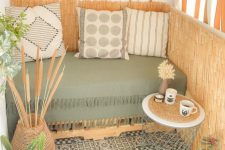 a fab boho balcony with a pallet sofa with boho pillows, a side table, potted greenery and some boho decor like fronds is a very cool space