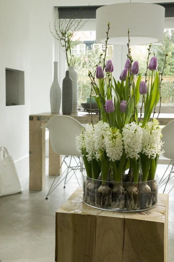 a glass bowl with purple tulips, white hyacinths, willow for a lovely modern spring decoration or centerpiece