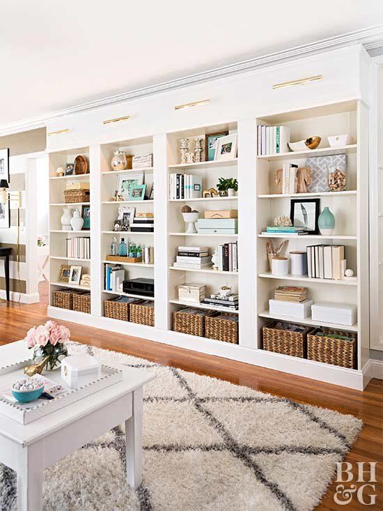 a large built-in bookshelf unit with lots of books, vases, baskets and candles is a cool idea for a home office