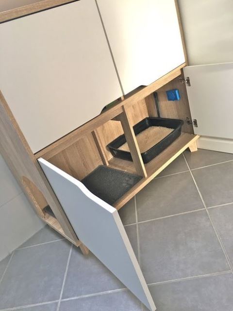 a minimalist cabinet with a cat litter box inside and more storage space aobve   it may be used for all the necessary things