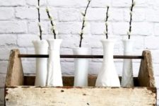 a rustic spring decoration of a tool box with white vases and willow will brign a cozy feel to your home