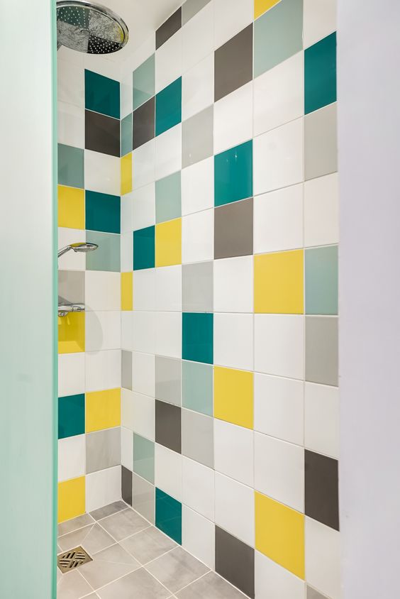a shower space clad with white, aqua, teal, grey and yellow tiles looks fun and cheerful and adds a fresh feel to the bathroom